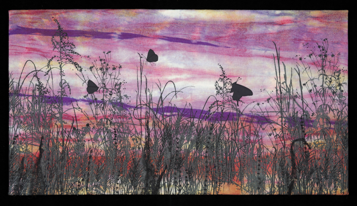 Three butterflies sitting on tall grass silhouetted against a colorful sky